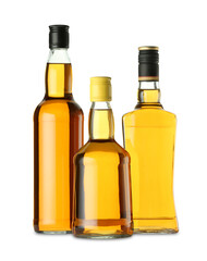 Different sorts of whiskey in glass bottles isolated on white