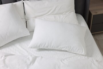 Fototapeta na wymiar Soft white pillows and duvet on bed at home