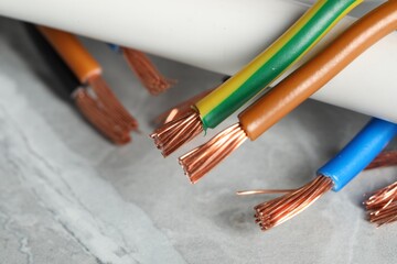 Colorful electrical wires on gray textured surface, closeup