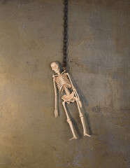 hanging human skeleton on an old wall