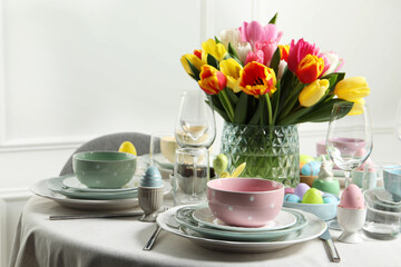 Easter celebration. Festive table setting with beautiful flowers and painted eggs