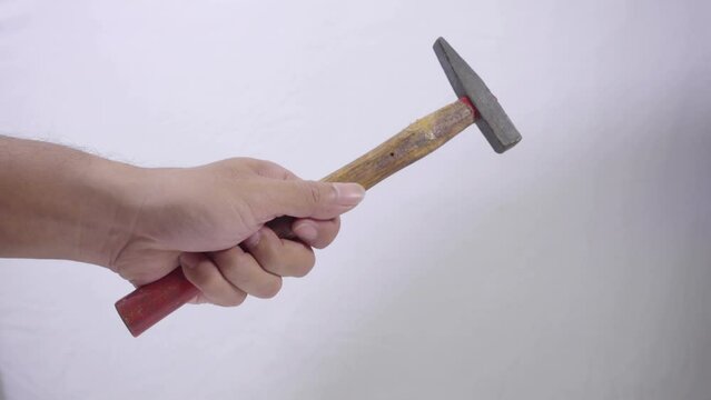 A man's hand holds small hammer with wood handle isolated on white