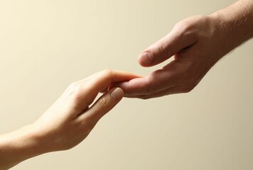 Man and woman holding hands together on beige background, closeup