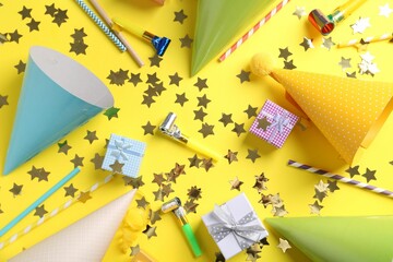 Flat lay composition with party hats on yellow background