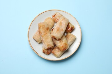Fried spring rolls on light blue table, top view