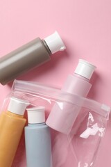 Plastic bag with cosmetic travel kit on pink background, flat lay. Bath accessories