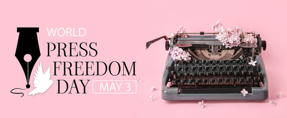 Vintage typewriter with lilac flowers on pink background