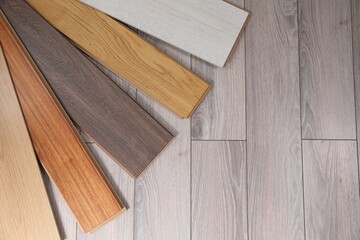 Different samples of wooden flooring on surface, top view. Space for text