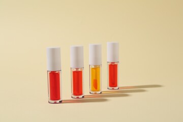 Many bright lip glosses on beige background