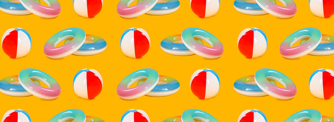 Many inflatable rings and beach balls on yellow background. Pattern for design