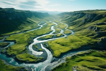 Breathtaking aerial view of a winding river flowing through lush, green mountains under a clear blue sky, showcasing the intricate dance between water and land in a serene natural landscape