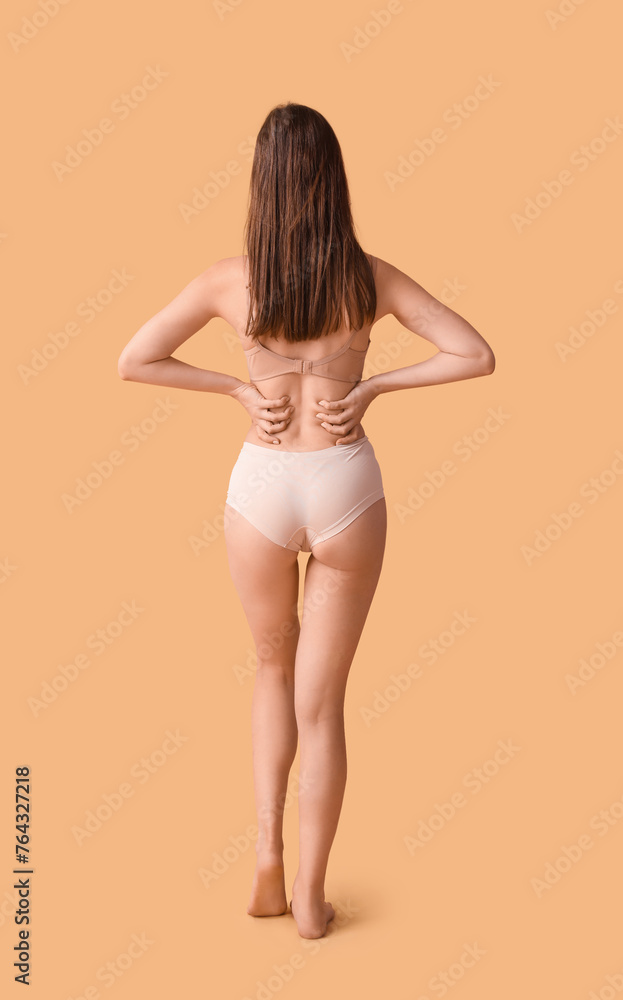 Wall mural Body positive woman in underwear on beige background, back view