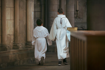 Boys with white tunic dress during communion in the church