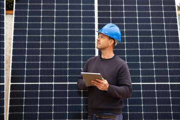 engineer checking solar panels for installation with his graphics tablet