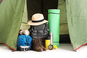 Camping tent with hiking equipment on white background