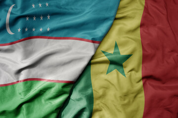 Obraz premium big waving national colorful flag of senegal and national flag of uzbekistan.