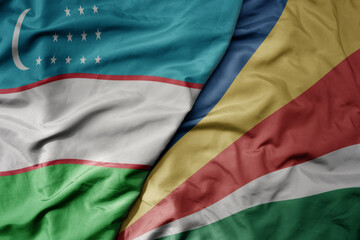 Obraz premium big waving national colorful flag of seychelles and national flag of uzbekistan.
