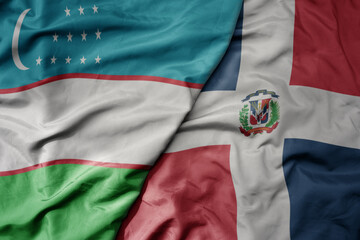 big waving national colorful flag of dominican republic and national flag of uzbekistan.