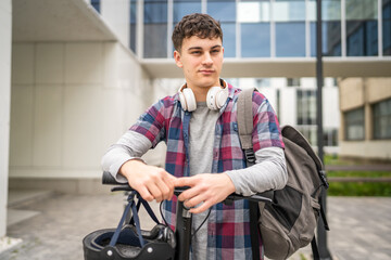 Young man caucasian teenager with electric kick push scooter in city