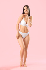 Naklejka premium Slim young woman in white underwear on pink background