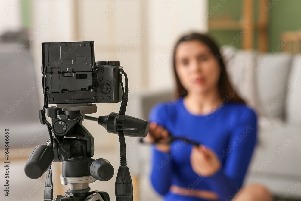 Wall mural Camera of female blogger recording sports video at home, closeup