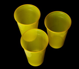 Empty new yellow disposable plastic cup isolated on black, clipping path - 764347404