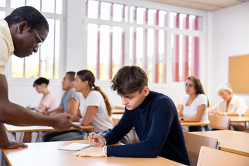 African american teacher prompts an adult student to solve the equation