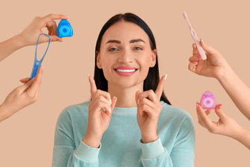 Beautiful young happy woman and hands holding supplies for oral hygiene on beige background