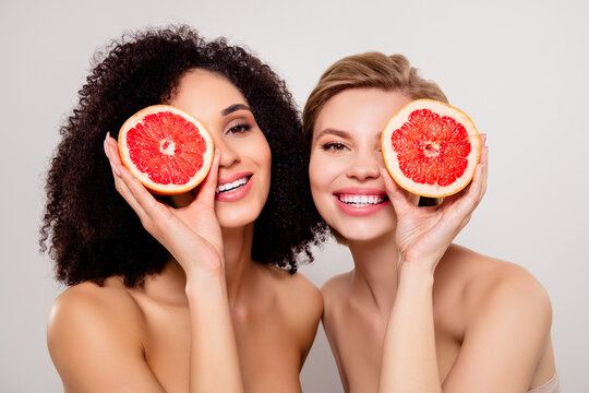 Photo of two girls cove rface with slice orange fruit over pastel color background