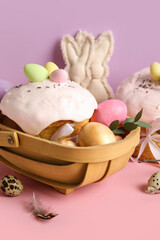 Composition with delicious decorated Easter cake and painted eggs in wooden basket on color background. Closeup
