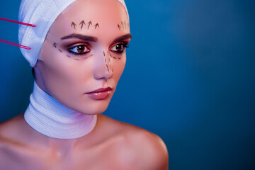 Photo of plastic surgery patient girl in facial medical bandage have tape tightening over neon blue color background