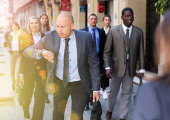 .Portrait of hurrying man among passers on street of city center