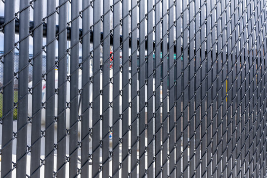Black vinyl coated chain link fence with vertical black privacy slats.