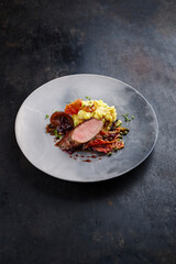 Traditionell gebratenes Wildhasen Rücken Filet mit Pflaumen, Kapern und Kartoffelsalat in...