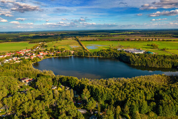 Aerial shot of beautiful lake surrounded by forest in a calm autumn day. Germany. - 764358039