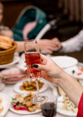 A woman's hand holds a glass of wine