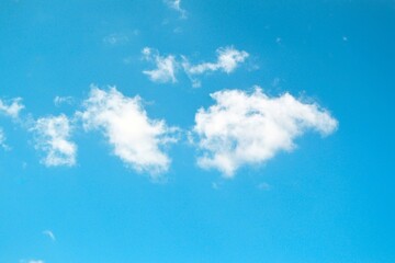 Fototapeta na wymiar Fluffy white clouds on clear blue sky background
