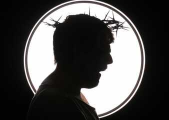Silhouette of man in Jesus robe and crown of thorns screaming on black background
