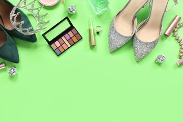 Female prom shoes with crown and makeup products on green background