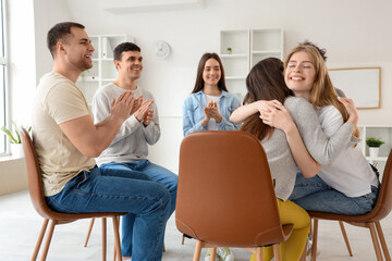 Young women hugging at group therapy session