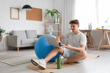 Fotobehang Young man with fitball using laptop at home © Pixel-Shot