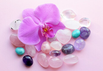 Beautiful rose quartz crystals and orchid flower. Healing crystals, the magic of precious stones.