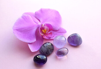 Obraz na płótnie Canvas Amethyst crystals and orchid flower. Healing crystals, the magic of precious stones.