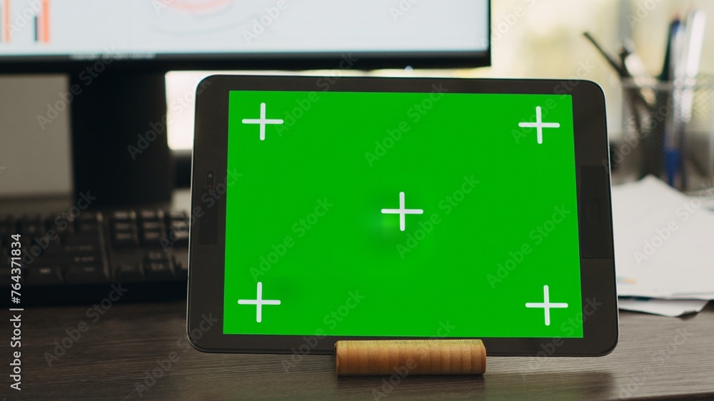 Poster empty desk with greenscreen on tablet in business coworking space, isolated copyspace layout on mode