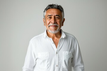 A man with a white shirt and gray hair is smiling