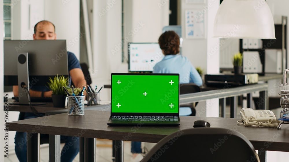 Poster laptop with greenscreen display on desk in modern startup agency office, wireless computer running i