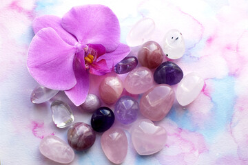 Amethyst crystals, rose quartz and orchid flower. Healing crystals, the magic of precious stones.
