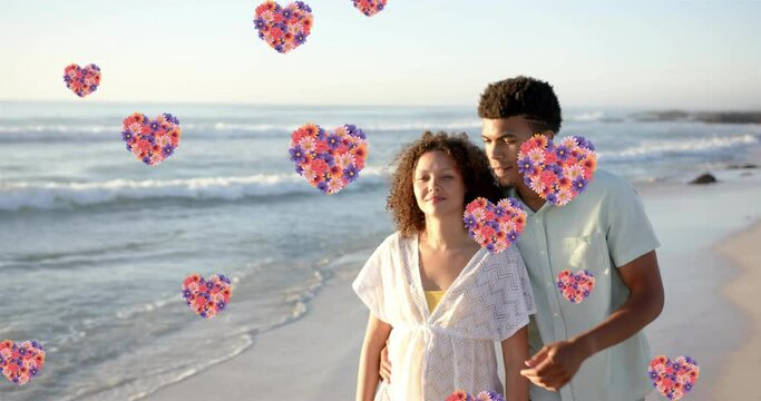 Animation of hearts moving over diverse couple in love on beach in summer