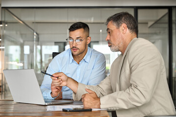 Two busy professional business people men executive team, male partners working using laptop...
