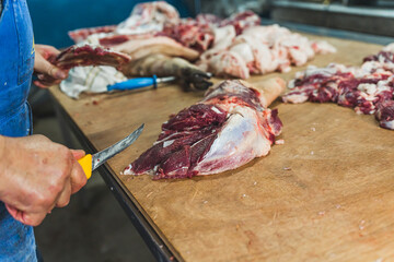 Butcher cutting pork meat into pieces for a meat market. Fresh raw pork chops in meat factory. High quality photo